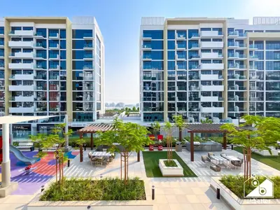 an apartment complex with a playground and buildings at Bright City ST with Balcony l Pool, Gym & Wi-Fi in Dubai