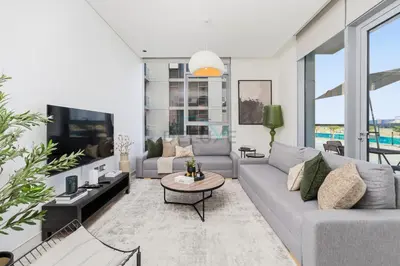 a living room with a couch and a table at Lagoon-Facing 1BR, Minutes from Downtown and Business Bay, Near Dubai Water Canal - District One Phase III Residences 18 by Deluxe Holiday Homes in Dubai