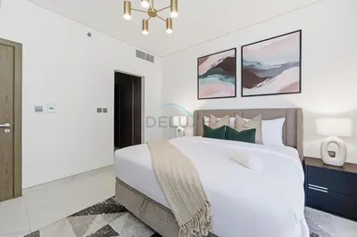 a white bedroom with a large bed and a chandelier at Lagoon-Facing 1BR, Minutes from Downtown and Business Bay, Near Dubai Water Canal - District One Phase III Residences 18 by Deluxe Holiday Homes in Dubai