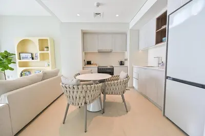 a kitchen and living room with a table and chairs at Vida Residences - Luxury & Serenity - Creek Beach in Dubai