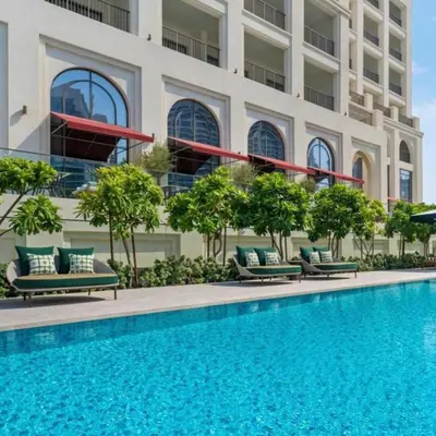 a hotel with a swimming pool in front of a building at Vida Residences - Luxury & Serenity - Creek Beach in Dubai
