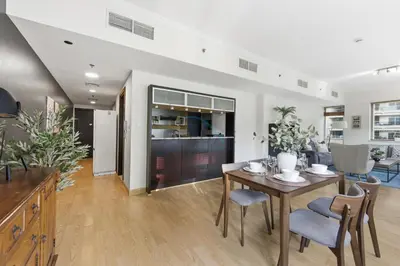 a dining room and living room with a table and chairs at Prime 2BR with Mesmerizing Canal Views, Stone Throw from Marina Mall and Metro, Minutes Walk to JBR Beach, Al Majara 1, Dubai Marina by Deluxe Holiday Homes in Dubai