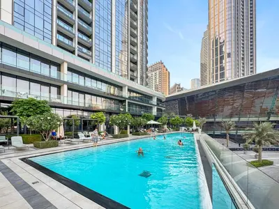a large pool in a city with people in it at Skyline Splendor 2bedroom with Burj Khalifa View in Dubai