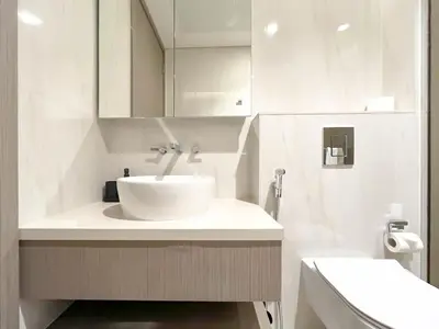 a white bathroom with a sink and a mirror at Luxury Canal-View Retreat l 3BR with Balcony & Pool in Dubai
