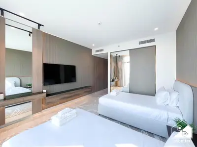 a bedroom with a large white bed and a tv at Luxury Canal-View Retreat l 3BR with Balcony & Pool in Dubai