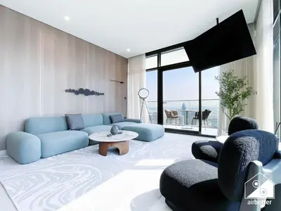 a living room with a blue couch and chairs at Luxury Canal-View Retreat l 3BR with Balcony & Pool in Dubai