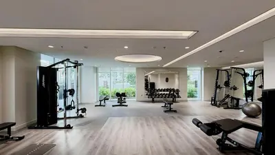 a gym with several treadmills and machines in a room at Beachfront 1BR with Private Beach Access in Dubai