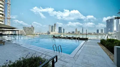 a large swimming pool with a view of a city at Beachfront 1BR with Private Beach Access in Dubai