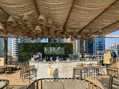 a patio with a bar with tables and chairs at Modern Canal Studio near Downtown Dubai in Dubai