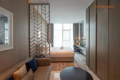a hotel room with a bed and a living room at Modern Canal Studio near Downtown Dubai in Dubai