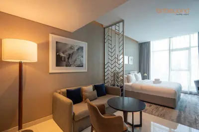 a hotel room with a bed and a couch and a table at Modern Canal Studio near Downtown Dubai in Dubai