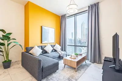 a living room with a couch and a tv at Best Business Bay Location - Direct Views of Canal and Al Khail Racecourse - 1 min from Al Habtoor Palace in Dubai