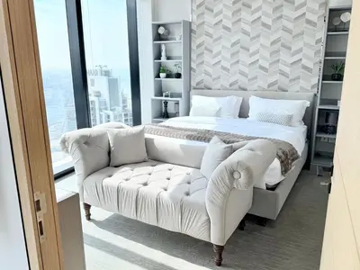 a bedroom with a white bed and a couch at JBR Beach Access Luxury1BR Marina View High Floor in Dubai