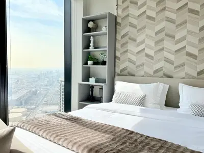 a bedroom with a large bed and a window at JBR Beach Access Luxury1BR Marina View High Floor in Dubai
