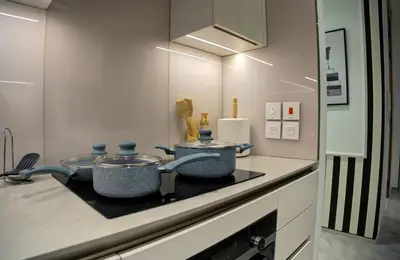 a kitchen with two pots on top of a stove at JBR Beach Access Luxury1BR Marina View High Floor in Dubai