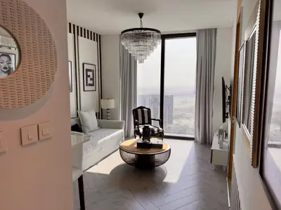 a living room with a chair and a large window at JBR Beach Access Luxury1BR Marina View High Floor in Dubai