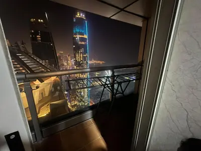 a view of a city skyline at night from a window at Private Room Steps from Marina Beach Dubai in Dubai