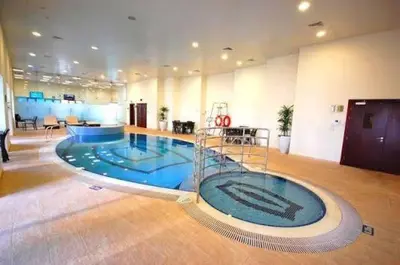 a large room with a swimming pool in a building at Private Room Steps from Marina Beach Dubai in Dubai