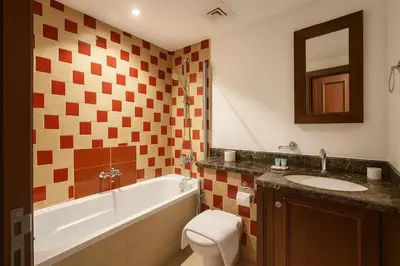 a bathroom with a tub and a sink and a toilet at Downtown Burj Khalifa View One Bedroom Apartment in Dubai
