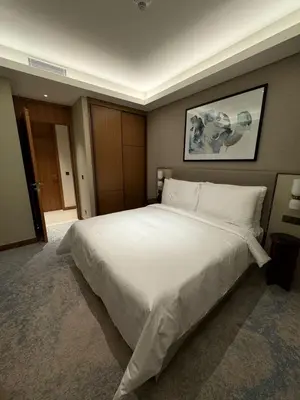 a bedroom with a large bed with white sheets at 2 Bedroom Apartment in Address Opera Residences in Dubai