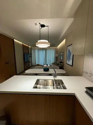 a kitchen with a sink and a living room at 2 Bedroom Apartment in Address Opera Residences in Dubai