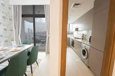a kitchen and dining room with a table and chairs at EasyGo - Chic 2-Bedroom with Dubai Skyline View in Dubai