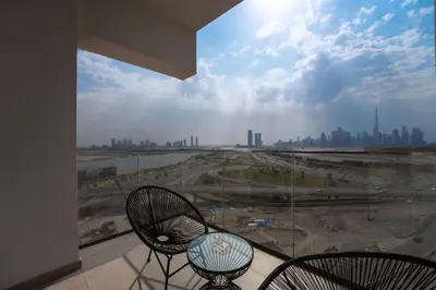 a balcony with two chairs and a view of a city at EasyGo - Chic 2-Bedroom with Dubai Skyline View in Dubai