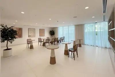 a room with tables and chairs in a building at Bright 1BR Walk to Beach Marina Vista Dubai in Dubai