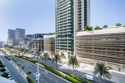 a city street with palm trees and buildings at Bright 1BR Walk to Beach Marina Vista Dubai in Dubai