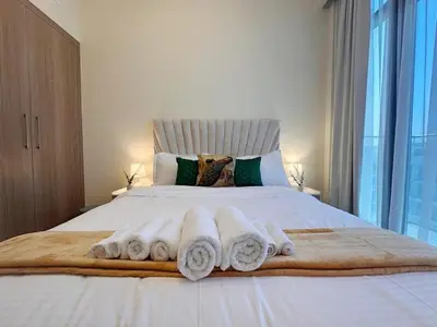 a bedroom with a large bed with towels on it at Kanisha Homes Azizi Riviera 48 by Vacay Xeal in Dubai