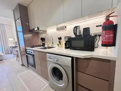 a kitchen with a sink and a washing machine at Kanisha Homes Azizi Riviera 48 by Vacay Xeal in Dubai
