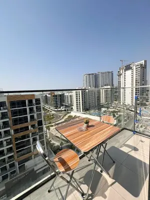 a wooden table on a balcony with a view of a city at Kanisha Homes Azizi Riviera 48 by Vacay Xeal in Dubai
