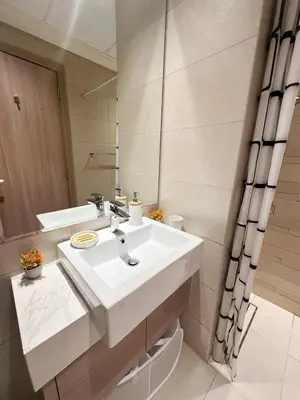 a bathroom with a white sink and a mirror at Kanisha Homes Azizi Riviera 48 by Vacay Xeal in Dubai