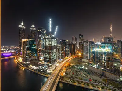 a city skyline at night with a river and buildings at New Renovate Huge Flat w Canal & Burj Khalifa view in Dubai