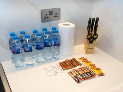 a counter with bottles of water and some candy at New Renovate Huge Flat w Canal & Burj Khalifa view in Dubai