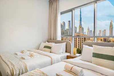 two beds in a room with a view of a city at Premium 3BR apartment with Burj Khalifa view, Downtown Dubai in Dubai