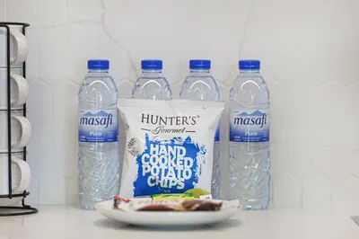 a group of bottles of water and a plate of food at Palace Beach Residences By Luxe Living - Palm & Marina View in Dubai