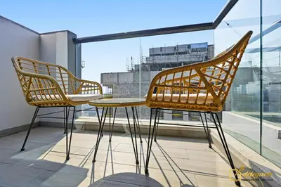 two chairs and a table on a balcony at 1BR Modern Escape in JVC Dubai in Dubai