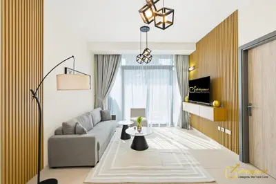 a living room with a couch and a table at 1BR Modern Escape in JVC Dubai in Dubai