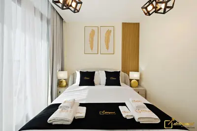 a bedroom with a bed with two towels on it at 1BR Modern Escape in JVC Dubai in Dubai