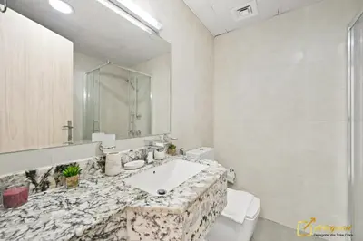 a bathroom with a sink and a toilet and a mirror at 1BR Modern Escape in JVC Dubai in Dubai
