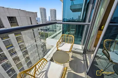 a balcony with chairs and tables on a building at 1BR Modern Escape in JVC Dubai in Dubai