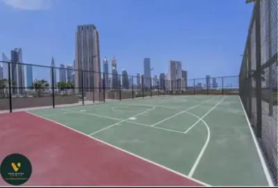 a tennis court with buildings in the background at Vogue Downtown Views II with Direct Access to Dubai Mall Via a Climate Controlled Bridge, One Bedroom Apartment with Balcony and City View in Dubai