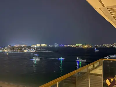 a view of the water at night from a balcony at Vogue Emaar Beachfront Grand Bleu Designed by Elie Saab, near JBR and Palm Jumeirah, Two Bedroom Apartment with Balcony and Private Beach, Access to all Amenities in Dubai