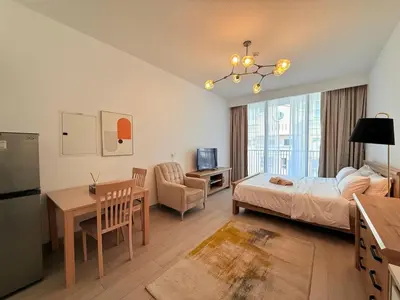 a bedroom with a bed and a table and a desk at Mahenti - Serene & Comfortable Apartment in Dubai