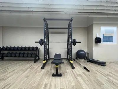 a gym with a squat rack and a chair at Mahenti - Serene & Comfortable Apartment in Dubai