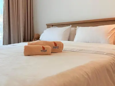 a bed with two towels sitting on top of it at Mahenti - Serene & Comfortable Apartment in Dubai