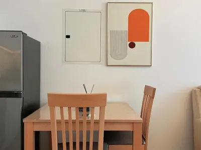 a kitchen with a wooden table with two chairs and a refrigerator at Mahenti - Serene & Comfortable Apartment in Dubai