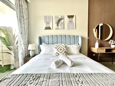 a bedroom with a white bed with a blue headboard at Luxury 2BR with Dubai Canal View Near Burj Khalifa in Dubai
