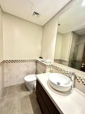 a bathroom with a sink and a toilet and a mirror at Luxury 2BR with Dubai Canal View Near Burj Khalifa in Dubai